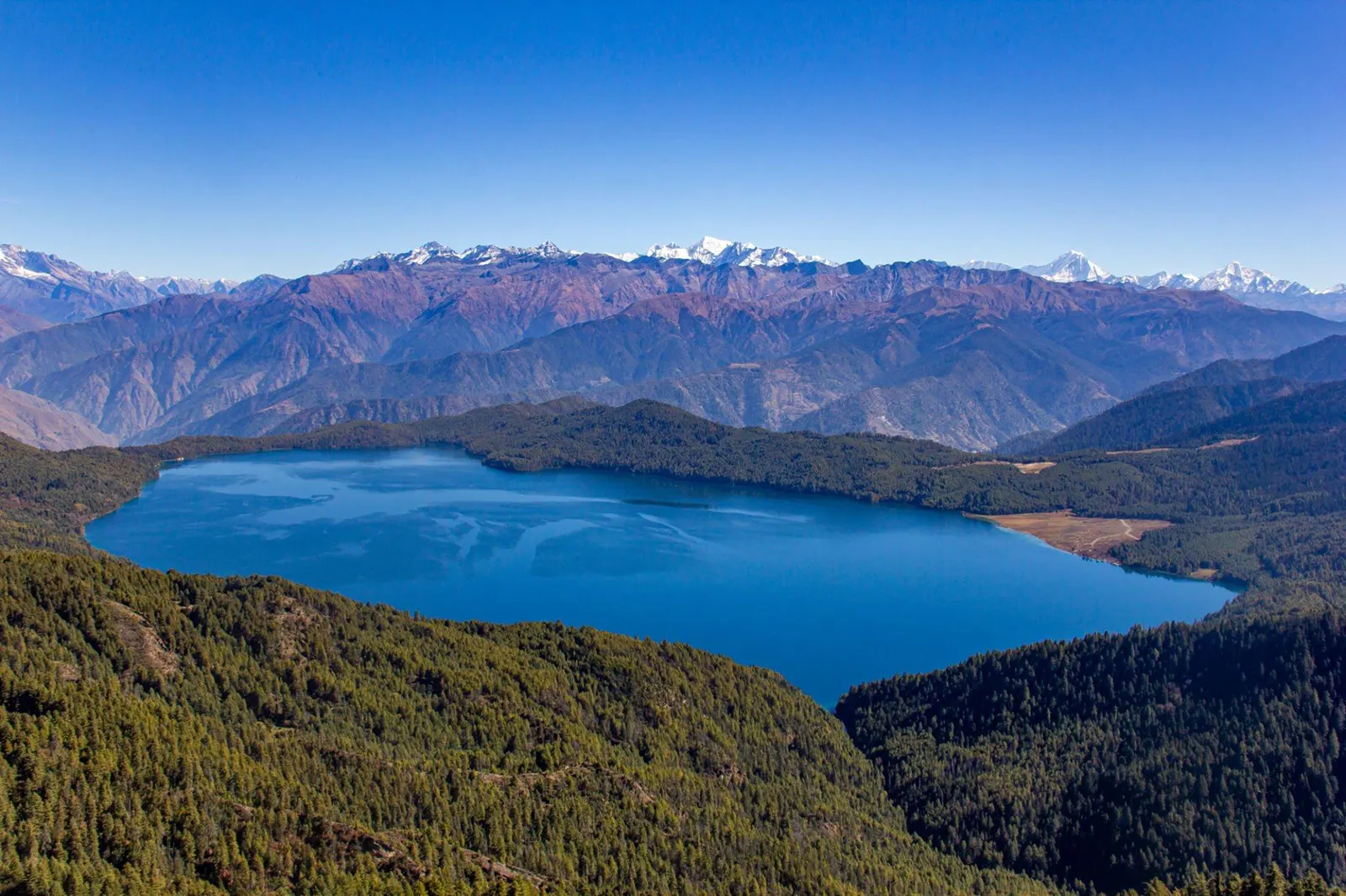 Scenic view of lake and mountains against clear blue sky,Rara Lake