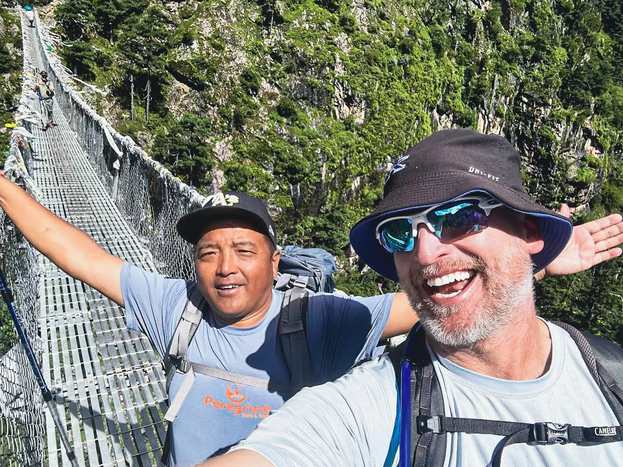 Peregrine guide and client crossing the Hillary Bridge on the Dudh Koshi River during the luxury Everest Base Camp trek