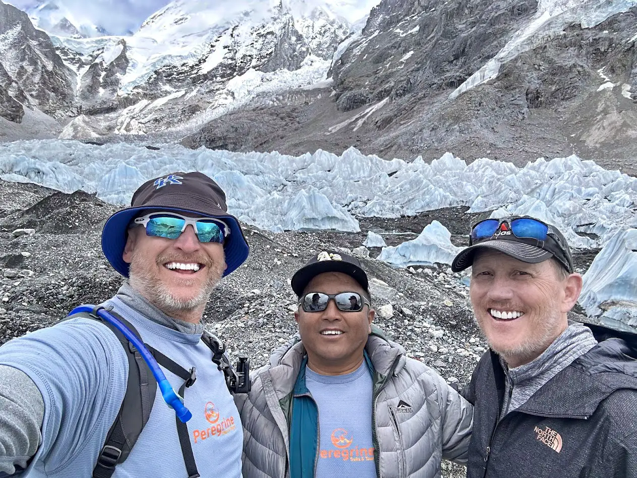 Peregrine guide and clients at the Khumbu Glacier with icefall seracs on the luxury Everest Base Camp trek