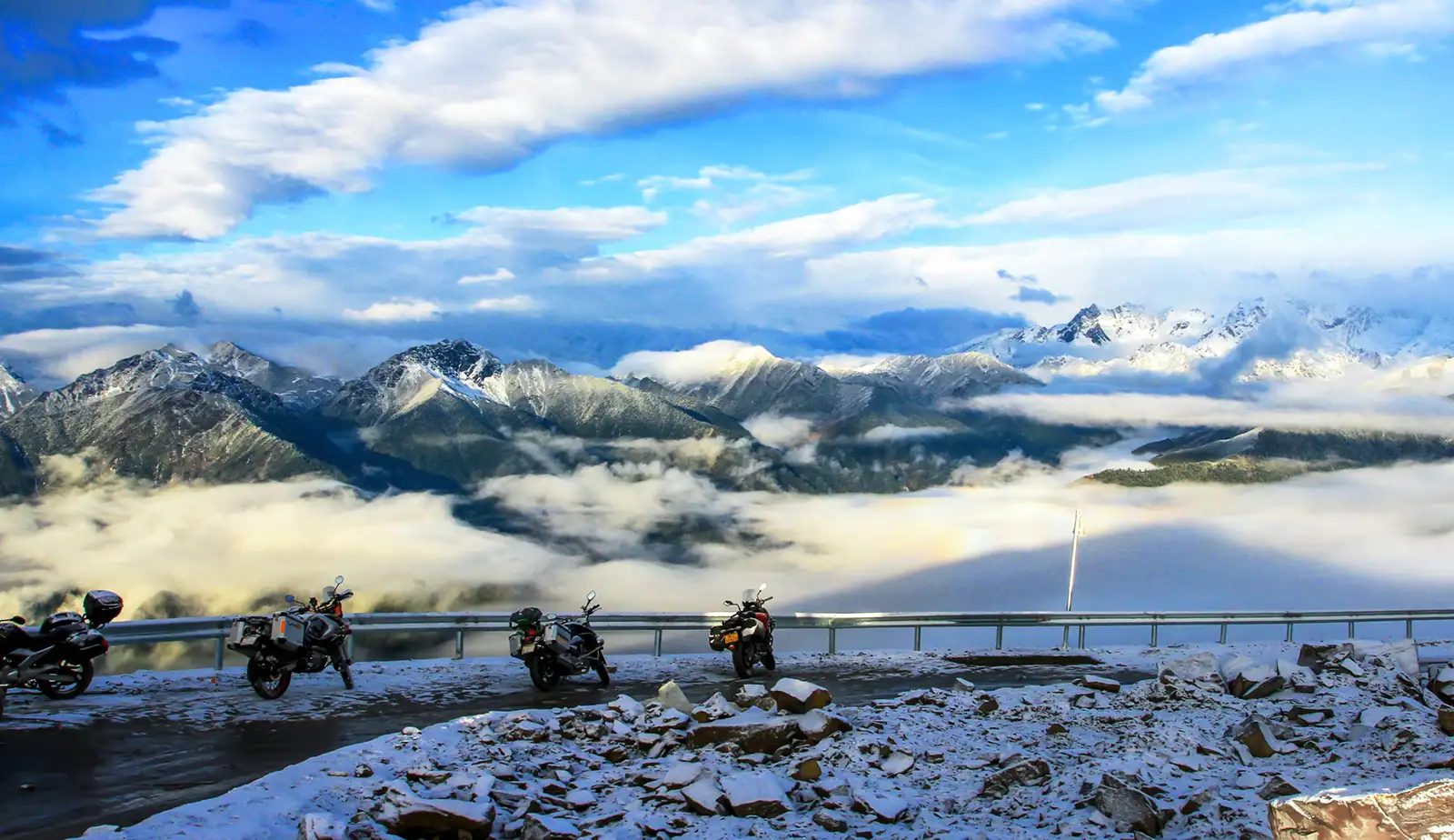 摩托车停在西藏的雪山公路上，山景令人惊叹。