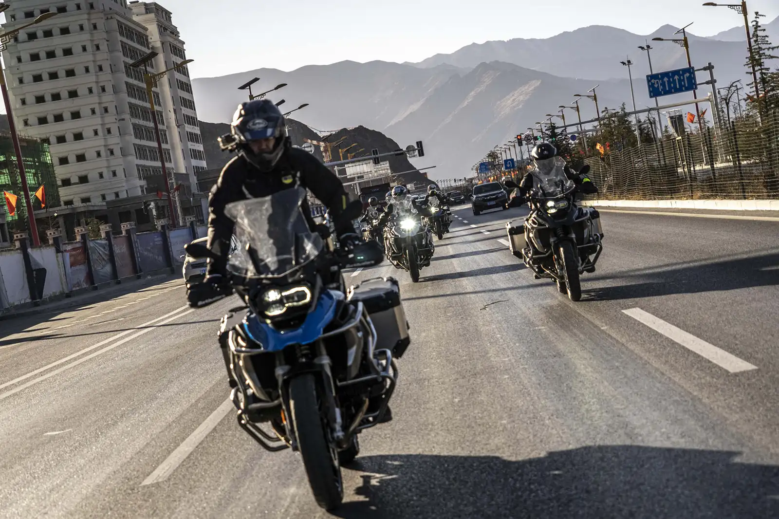 一群摩托车手骑着车穿过西藏拉萨的街道。