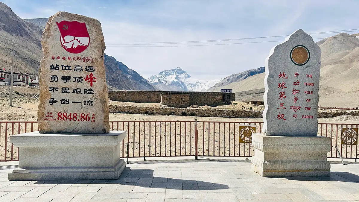 Two stone markers at the North Everest Base Camp in Tibet, with Mount Everest visible in the background.