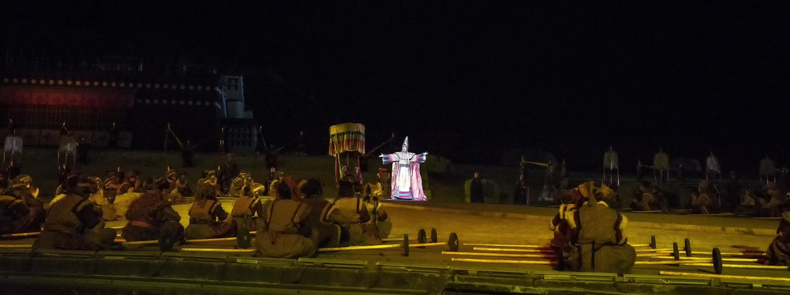 A night-time performance of the Princess Wencheng opera in Tibet, with a brightly lit stage and actors in elaborate costumes.