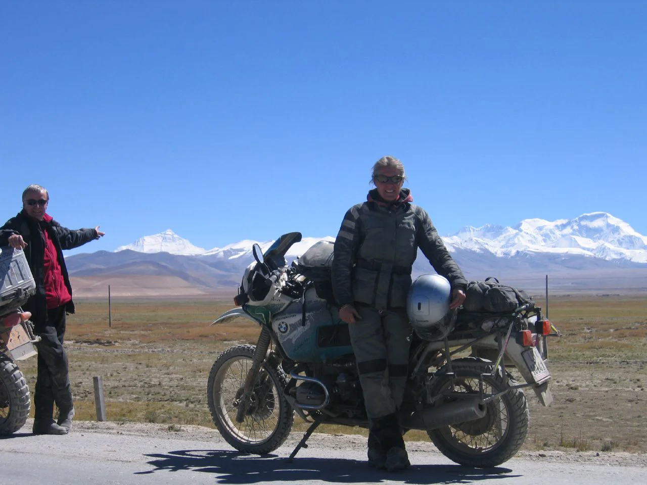 两名摩托车手在西藏摩托车之旅中，背景是珠穆朗玛峰