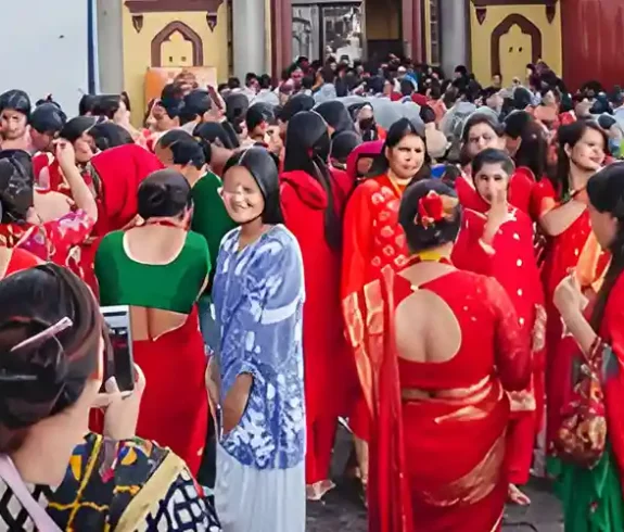 Wide panoramic view of Hindu women in red sarees gathered at Pashupatinath Temple in Kathmandu for the Teej festival, engaged in prayer and celebration.