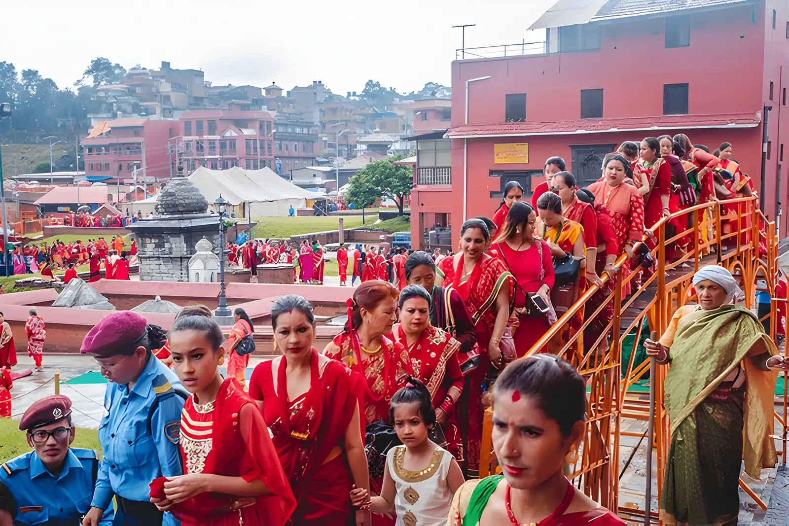 A large group of Nepali Hindu women in vibrant red sarees lining up to worship at Pashupatinath Temple during the Teej Festival in Kathmandu.