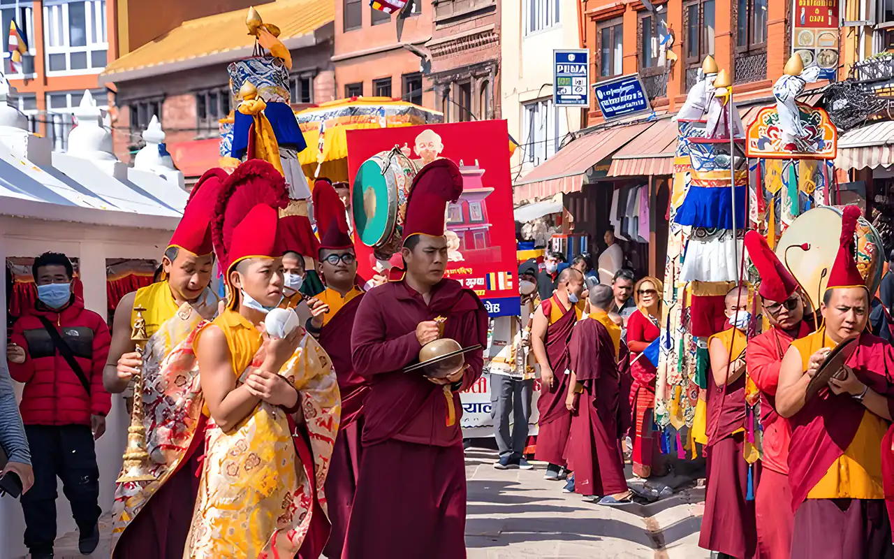 Monks in traditional robes and ceremonial hats play musical instruments during a parade around Boudhanath Stupa for Buddha Jayanti in Kathmandu.