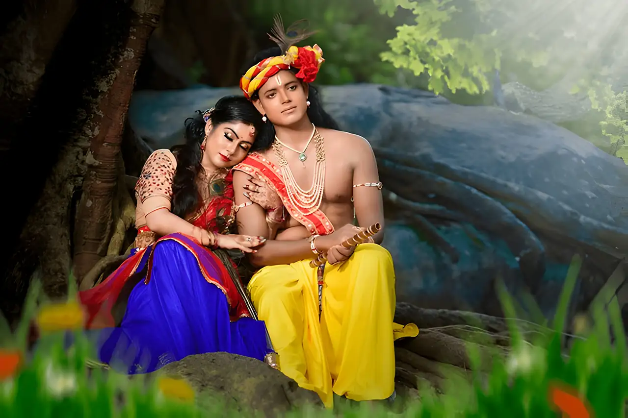 A couple in a pre-wedding photoshoot styled as Radha and Krishna in a serene forest setting near Basistha Temple, Assam.