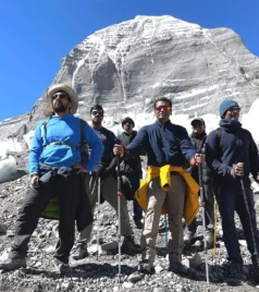 Group of trekkers standing in front of Mount Kailash with trekking gear.