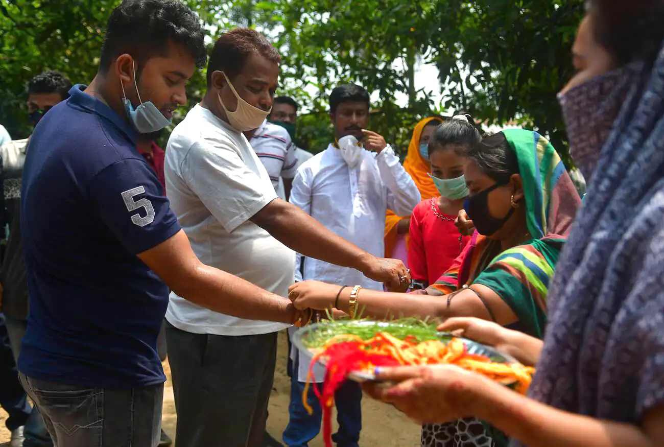 A Hindu girl ties a Rakhi on the wrist of a Muslim man during the Raksha Bandhan festival in Agartala, Tripura, symbolizing brotherhood and unity across religions.