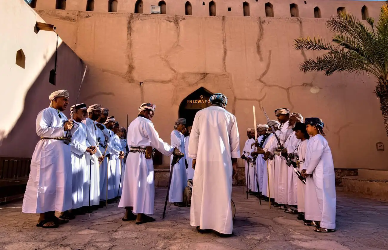 Traditional Omani sword dance, performed by men in Nizwa, Oman, wearing white robes and holding khanjars (Omani daggers).