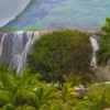 Pemandangan hijau subur dengan air terjun yang dikelilingi oleh vegetasi tropis selama musim Khareef di Oman