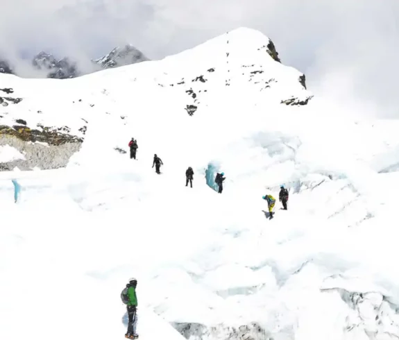 Climbers ascending Island Peak through snow-covered crevasses in the Himalayas.
