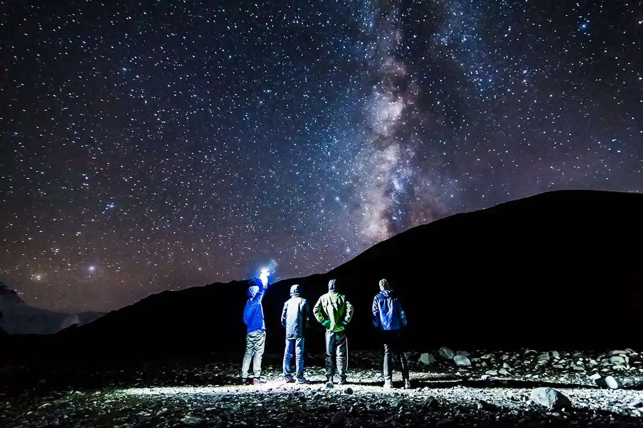 Tourists gazing at the Milky Way galaxy under a starry sky in Tingri, Tibet.