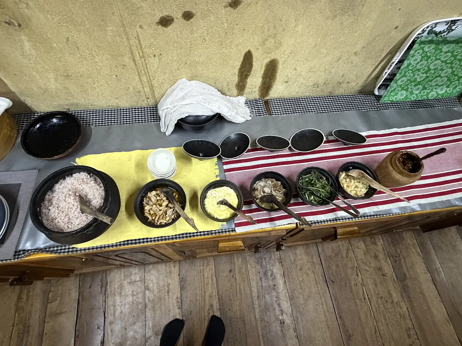 Traditional Bhutanese meal spread with red rice, ema datshi, and side dishes in clay bowls