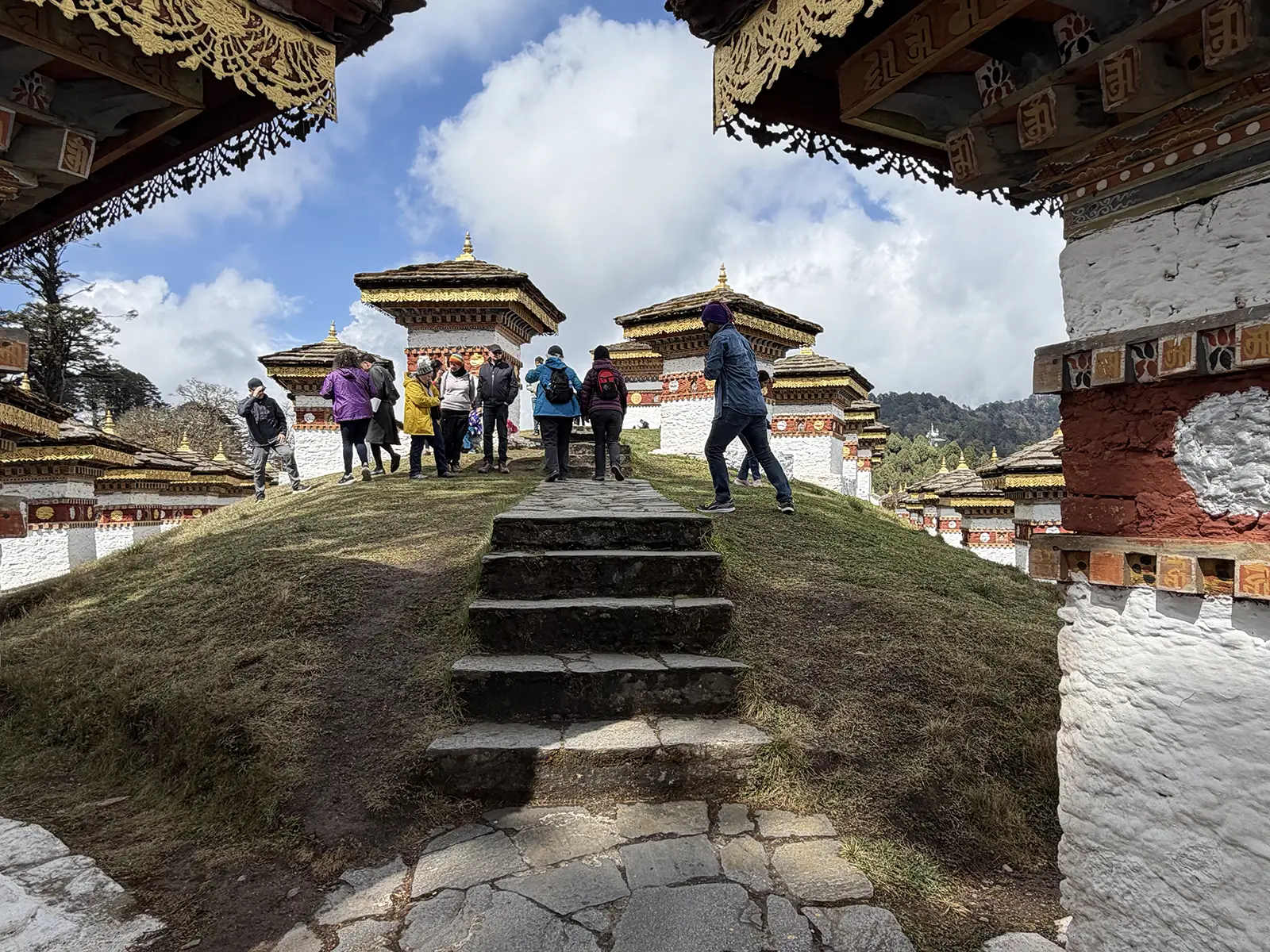 Hikers walking among the 108 Druk Wangyal Chortens at Dochula Pass Bhutan