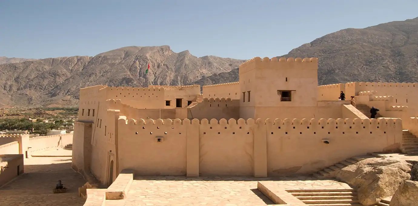 Nakhal Fort in Oman with rugged mountains in the background.