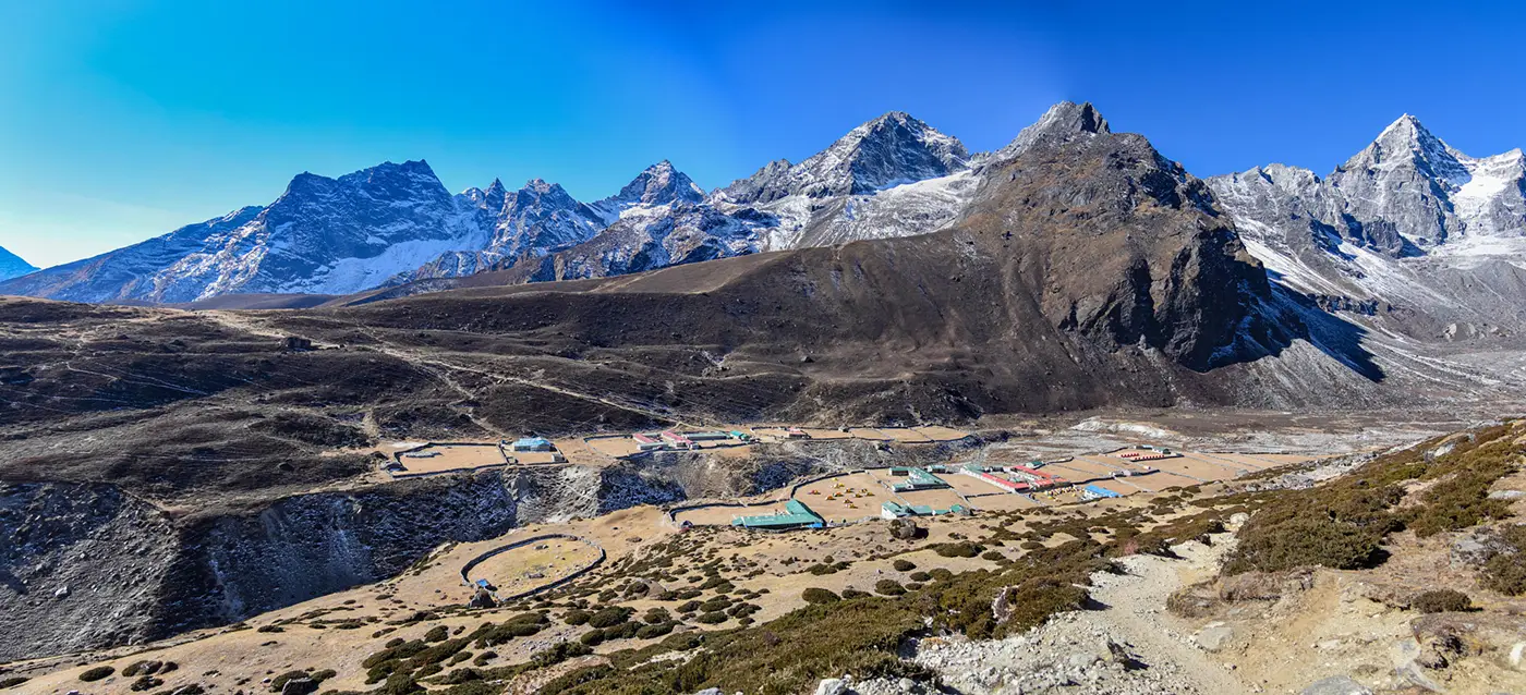 Panoramic view of Machhermo village at 4,400 meters with high Himalayan peaks and alpine terrain on the Gokyo trekking route