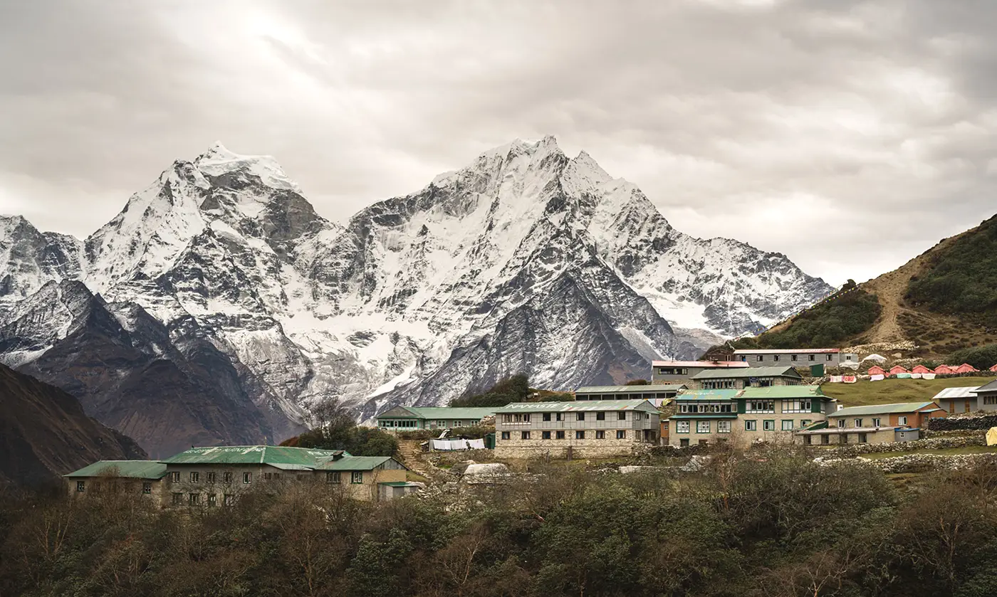 Dole village in the Everest region with stone lodges and snow-covered Himalayan peaks rising behind the settlement