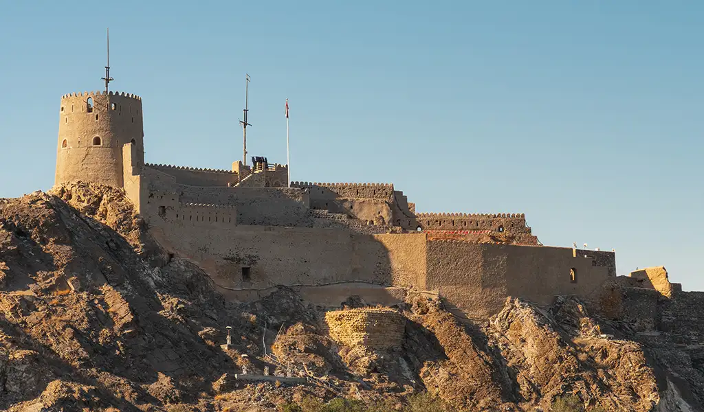 Mutrah Fort perched on a rocky hill overlooking Muscat, showcasing Oman’s historic coastal defense architecture.