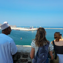 Travelers overlooking Muscat harbor during the Oman Grand Explorer tour, enjoying coastal views and local culture.