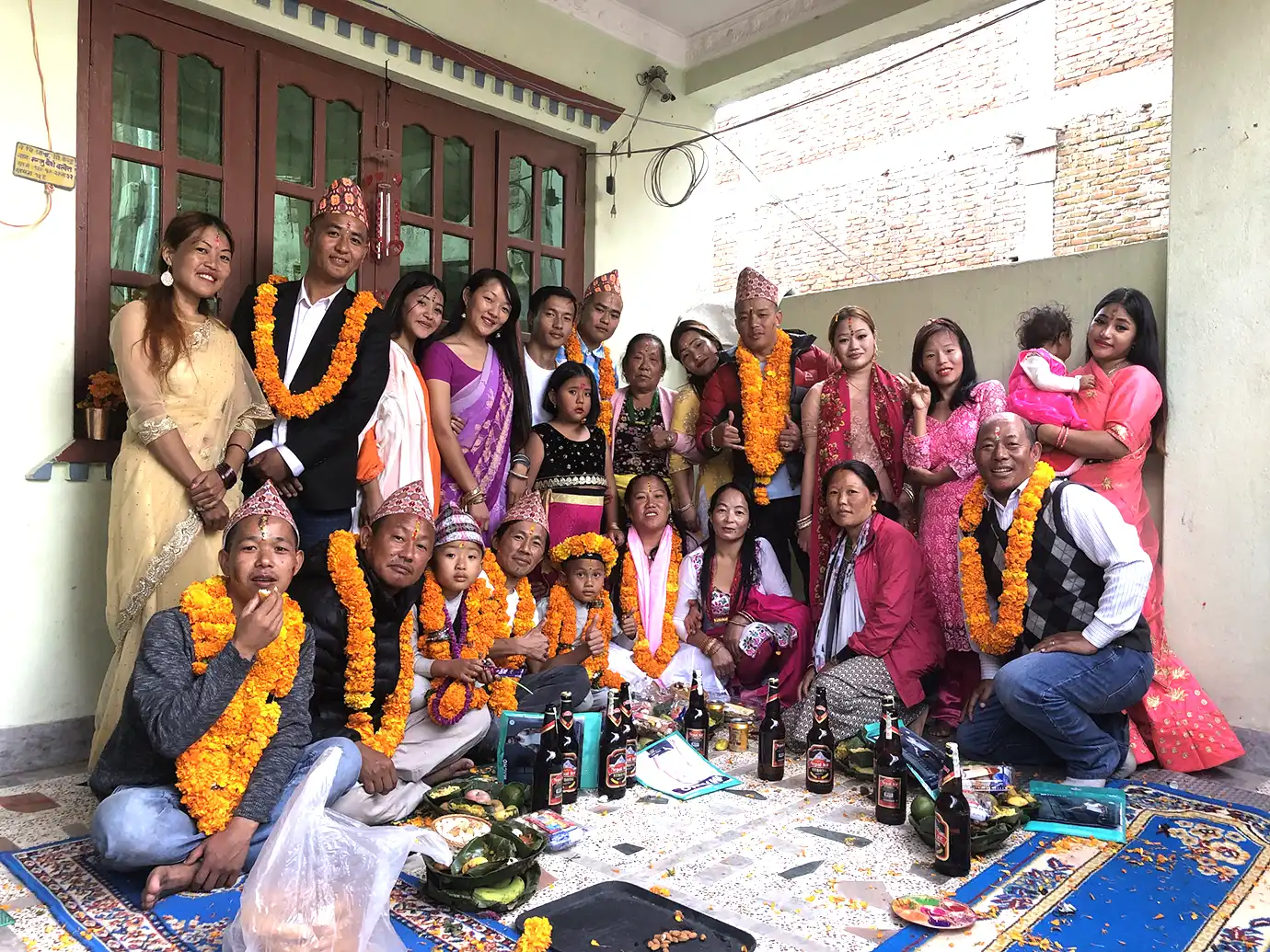 Nepali family celebrating Tihar festival together with marigold garlands and traditional attire
