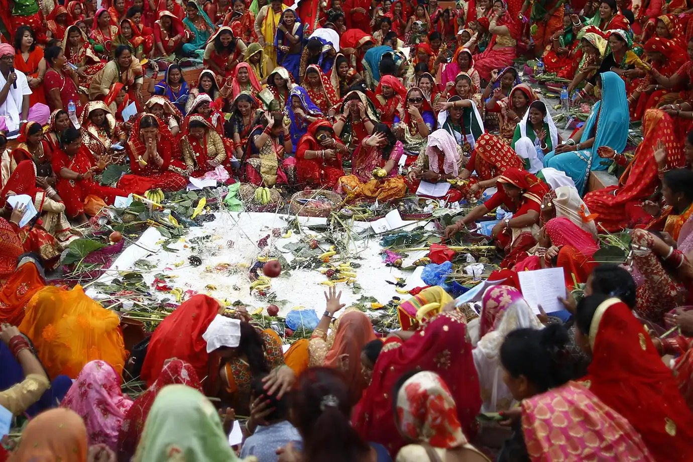 Women celebrating Jitiya Festival in Nepal, dressed in red saris during a traditional ritual gathering