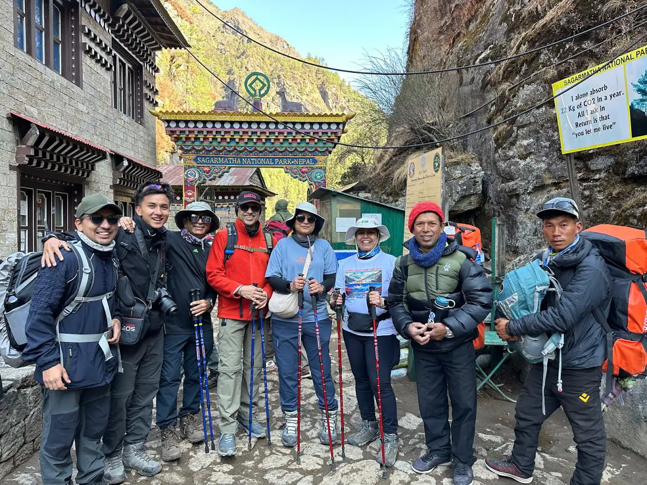 A diverse group of trekkers stands at the entrance gate of Sagarmatha National Park, ready to test their Everest Base Camp trek fitness level on the journey ahead toward the world's highest peak.