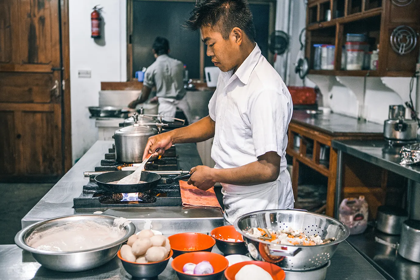 Chef preparing fresh meals in a mountain lodge kitchen for the Luxury Everest Base Camp Trek Food experience.