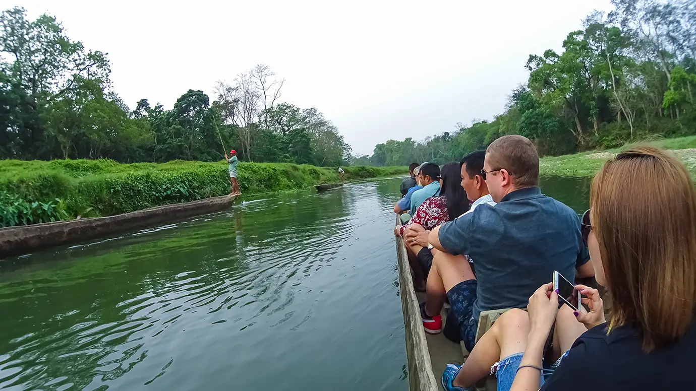 Canoe ride in Chitwan National Park Nepal with tourists exploring river and jungle landscape