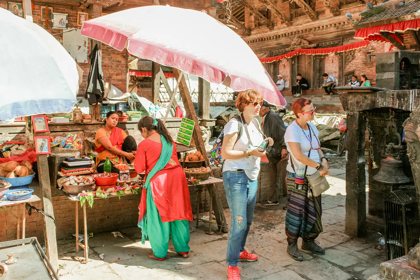 Local market scene in Kathmandu Nepal with vendors, tourists, and traditional temple surroundings