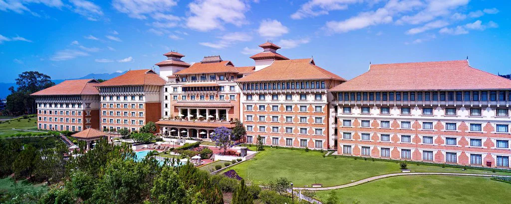 Best 5-Star Hotels in Kathmandu featuring a grand resort-style hotel with Newari-inspired architecture, landscaped gardens, open lawns, and a clear blue sky