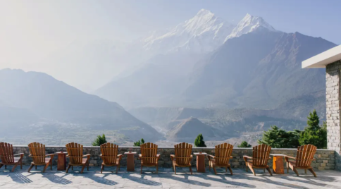 Man standing by large window in a luxury lodge overlooking mountains and valley in Mustang.