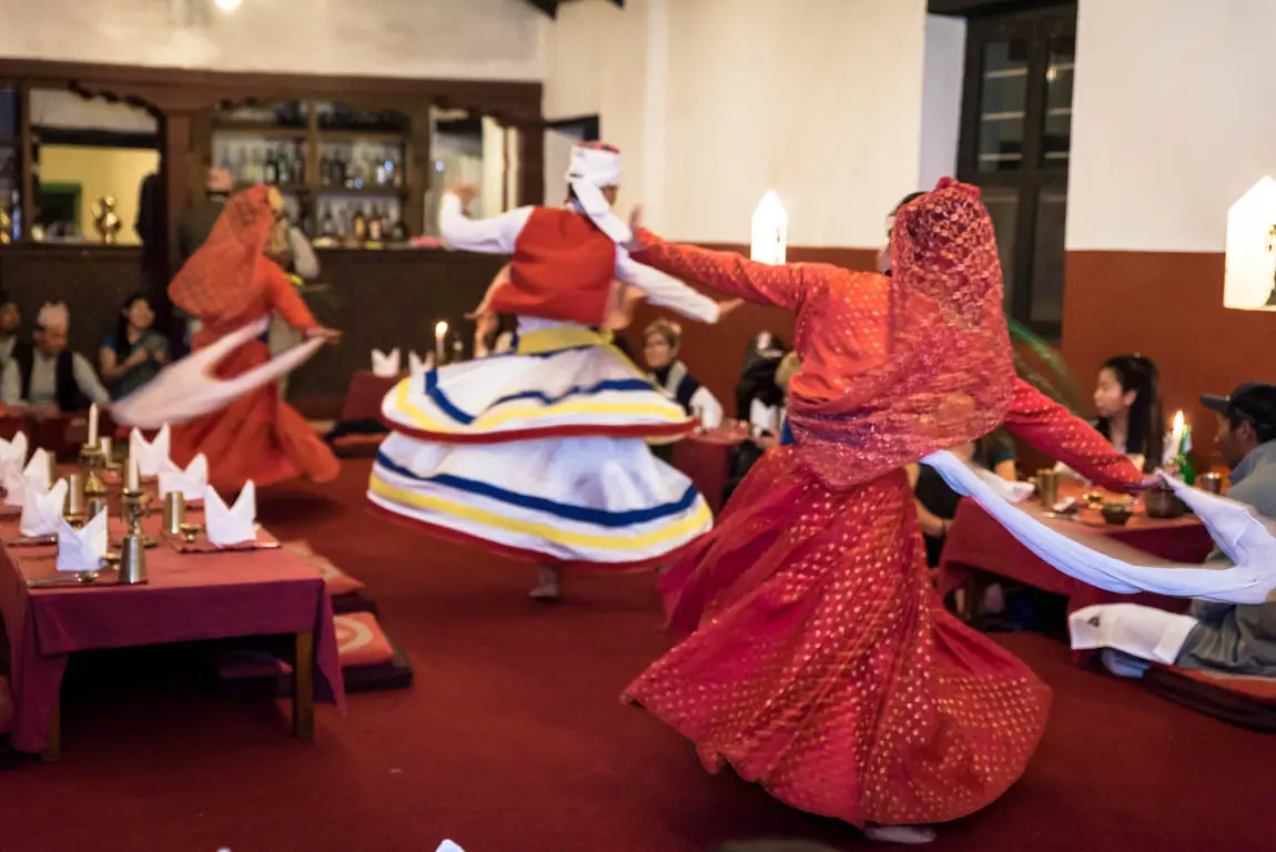 Traditional Nepali dancers perform during a cultural dinner experience in Kathmandu, featured as part of a Nepal Luxury Tour Itinerary with authentic heritage entertainment.