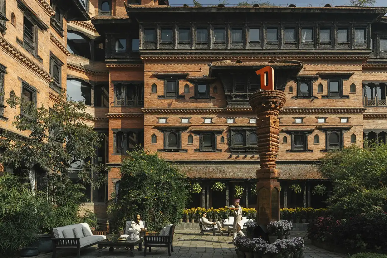 Guests relax in the historic brick courtyard of Dwarika's Hotel, helping travelers decide: is a luxury Nepal tour worth the price for culture.