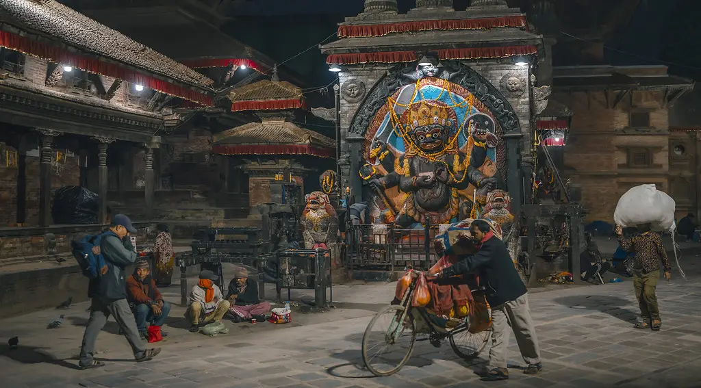 The brightly painted Kal Bhairav statue stands in Kathmandu's Durbar Square at night, a culturally rich stop included in a Nepal Luxury Tour from India.