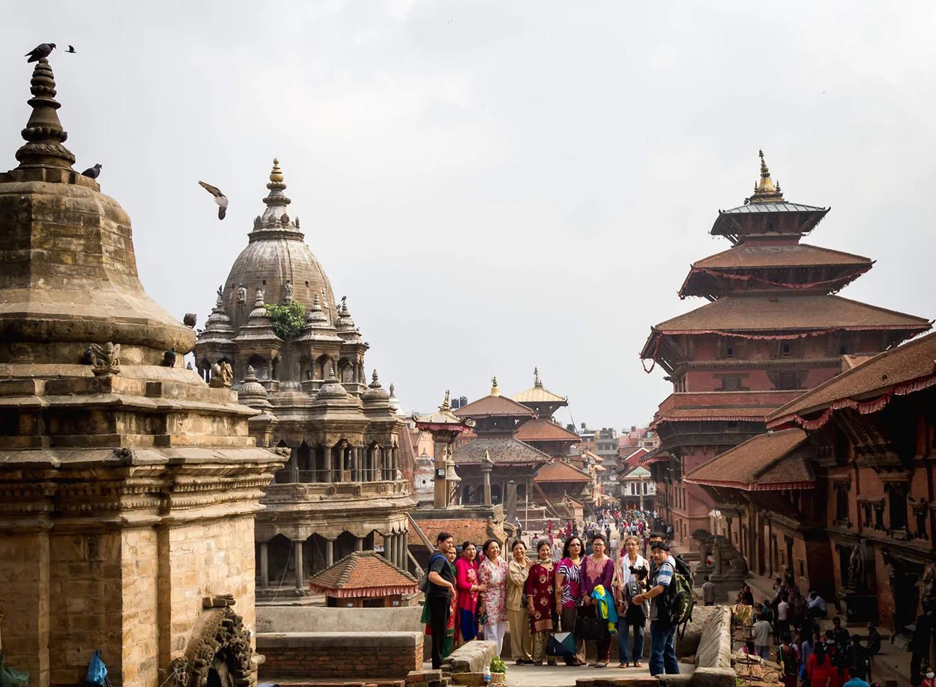 A vibrant group stands in historic Patan Durbar Square, Kathmandu, before beginning their Luxury Everest Base Camp & Gokyo Lakes Trek, surrounded by ancient temples and palaces.