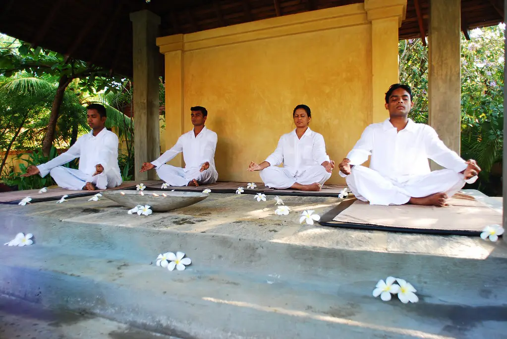 Ayurveda in Sri Lanka is highlighted as individuals practice yoga and meditation in white attire at the Jetwing Ayurveda Pavilions in Negombo.