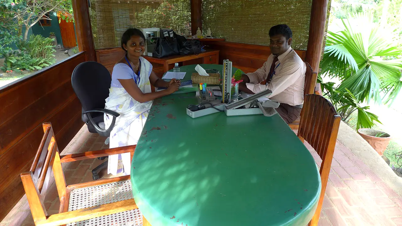 Ayurveda in Sri Lanka is highlighted as two practitioners sit at a consultation desk during a wellness retreat.