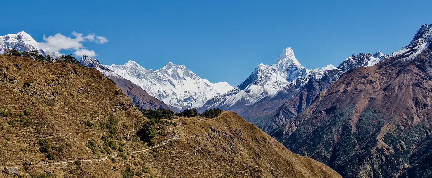 Best Time to Visit Nepal features panoramic views of iconic snow-capped Himalayan summits including Mount Amadablam, Lhotse, and Everest under a clear blue sky.