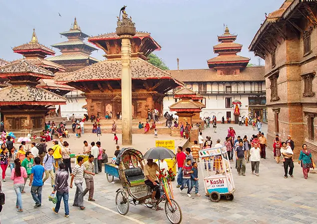 Things to do in Kathmandu features a bustling historic square filled with ancient Newari architecture, temples, and crowds of people.