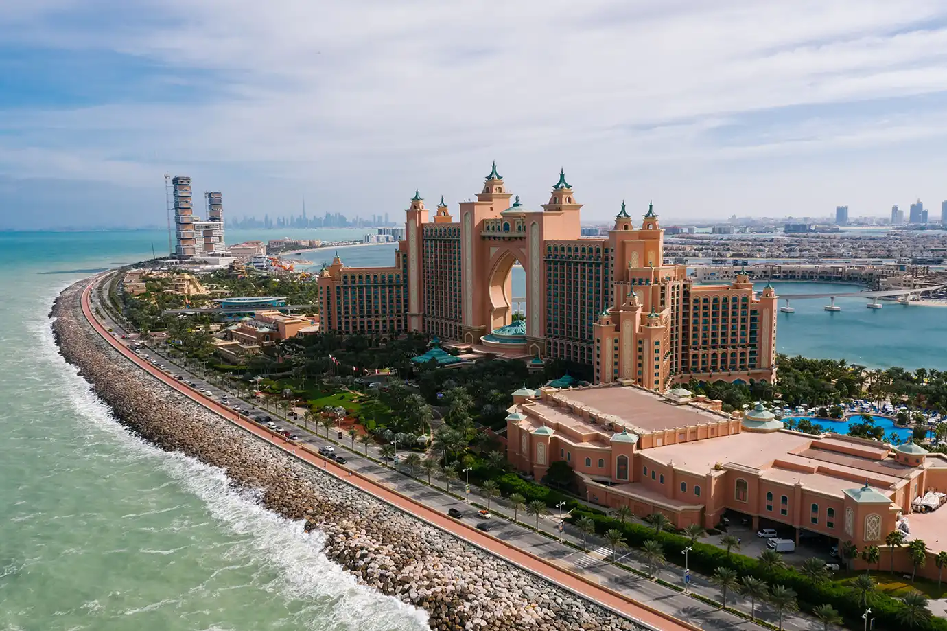 An aerial view of the iconic Atlantis, The Palm luxury resort building on Palm Jumeirah surrounded by turquoise waters, a top landmark for Things to Do in Dubai.