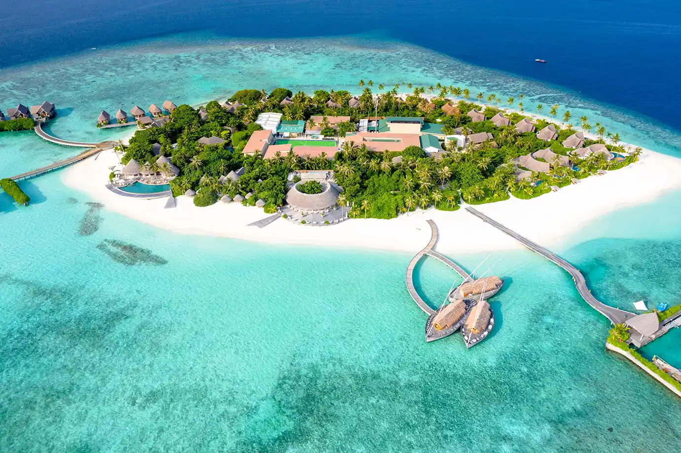 A high-angle view of a tropical resort island surrounded by pristine white beaches and turquoise waters featured in a guide on How to Plan a Maldives Luxury Honeymoon on an Affordable Budget.