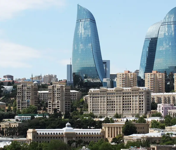 Panoramic cityscape view of Baku featuring the Flame Towers glass skyscrapers and TV Tower rising above historic urban architecture featured in a travel guide on 10 Essential Things to Know Before Visiting Azerbaijan. Azerbaijan Travel Tips