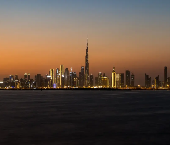A panoramic night view of the illuminated Downtown Dubai skyline featuring the towering Burj Khalifa, one of the top Things to Do in Dubai.
