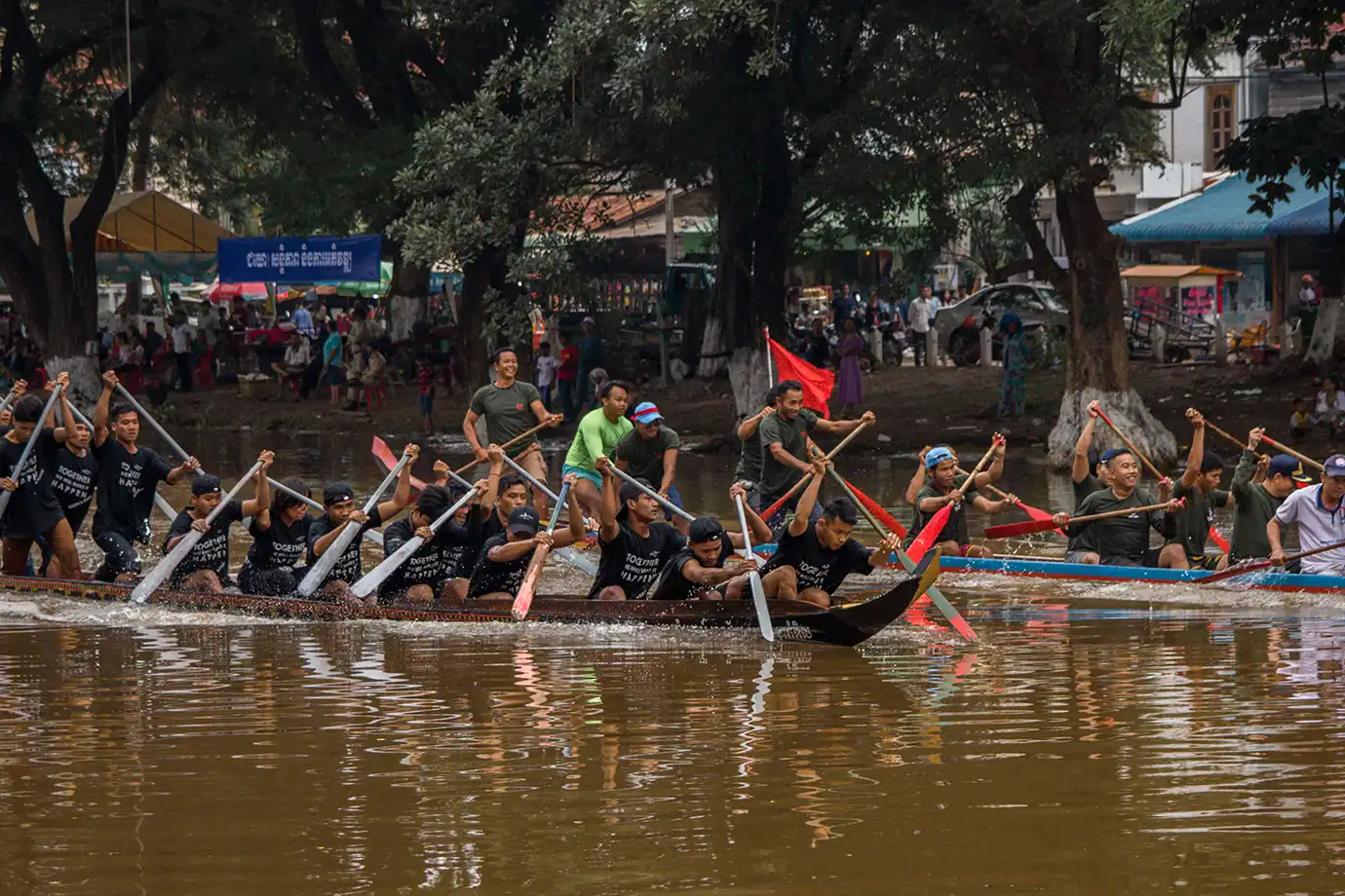 A team of Cambodian rowers paddling synchronized long wooden boats during the annual Water Festival featured in a travel guide on the Best Time to Visit Cambodia.