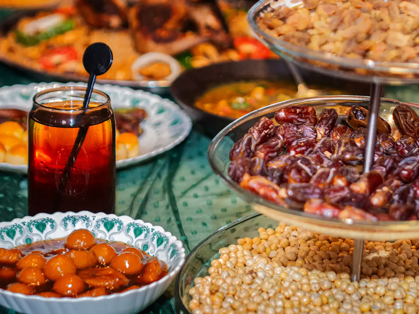 A colorful spread of traditional Ramadan foods including dried dates, luqaimat sweets, roasted chickpeas, and tea served for Iftar, featured in Best Time to Visit Dubai.
