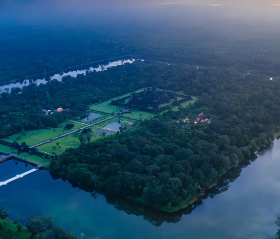 An aerial panoramic view showing the rectangular moat and dense canopy around Angkor Wat featured in a guide on Things to Do in Siem Reap Beyond Angkor Wat.