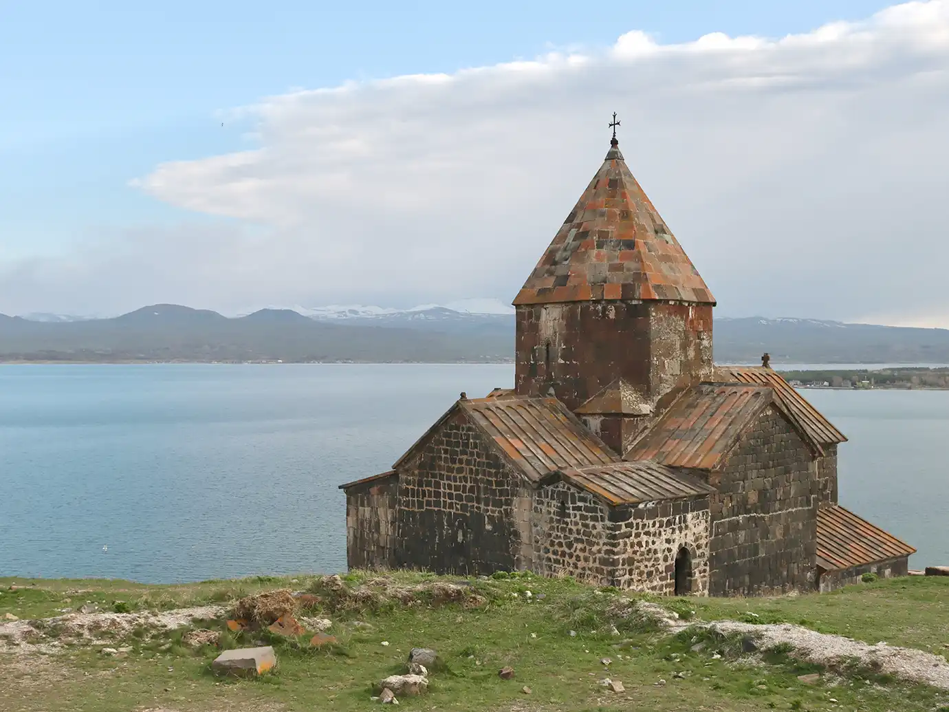 Medieval black tuff stone church of Sevanavank Monastery on a hilltop overlooking Lake Sevan featured in a travel guide on 5 Must-See Monasteries in Armenia.