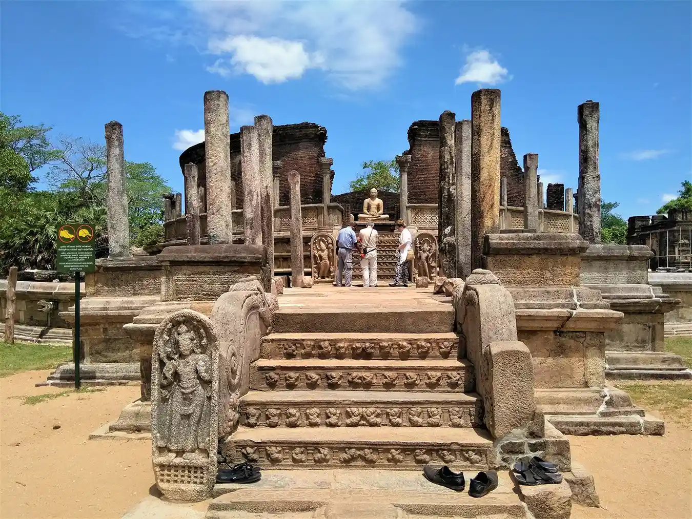 Visitors exploring the ancient stone steps, guardstones, and central Buddha statue at the Polonnaruwa Vatadage.
